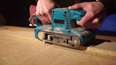 belt sander in use on wood plank