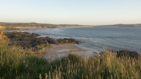 panoramic view of rolling waves and surrounding coastline at godrevy, panning shot