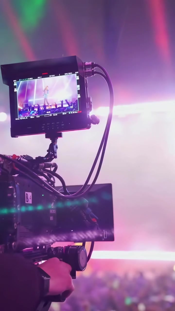 Câmera de Vídeo Profissional Filmando Concerto ao Vivo com Iluminação de Palco Vibrante