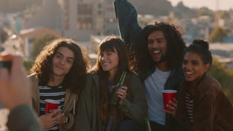 happy friends hanging out on rooftop posing for photo enjoying weekend party celebration having fun sharing celebrating friendship at sunset