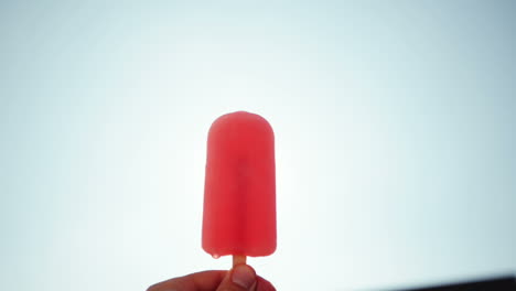 man holding ice lolly point of view walking through city