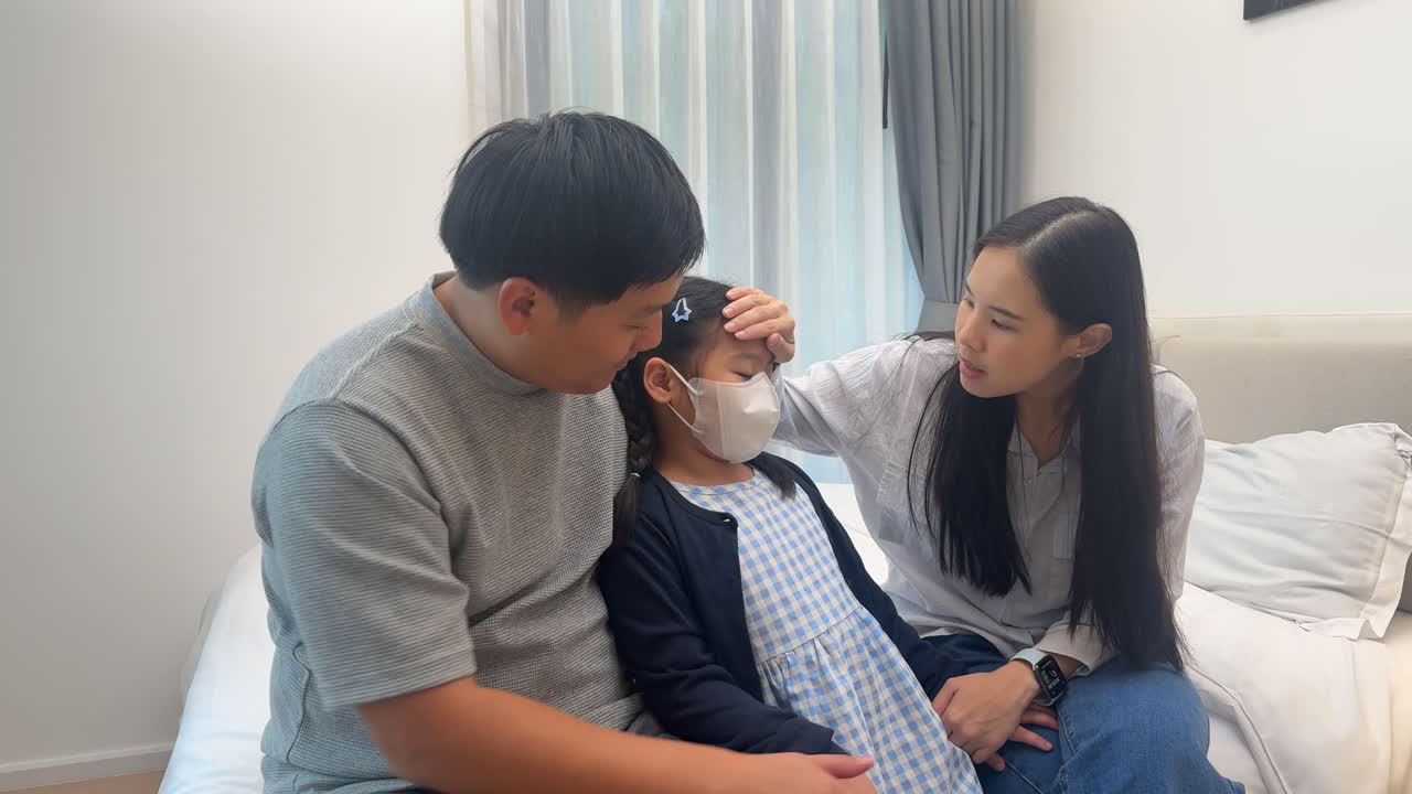 Parents lovingly care for their sick child in a cozy, softly lit bedroom, showing concern