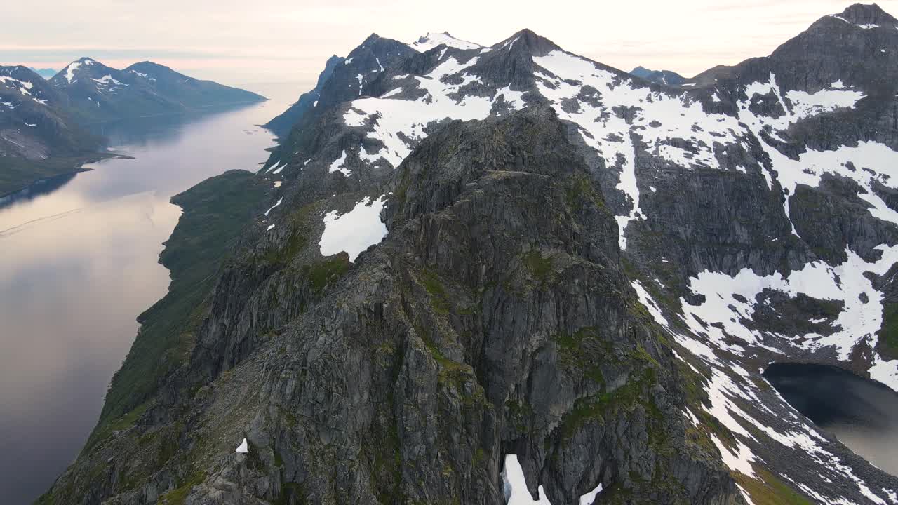 Droneopptak av de fantastiske fjellene og fjordene på Kvaløya i Nord-Norge sent på kvelden under midnattssolperioden.