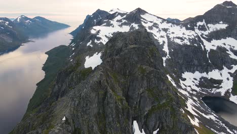 drone footage of the amazing mountains and fjords of kvaløya in northern norway late at night during midnight sun season