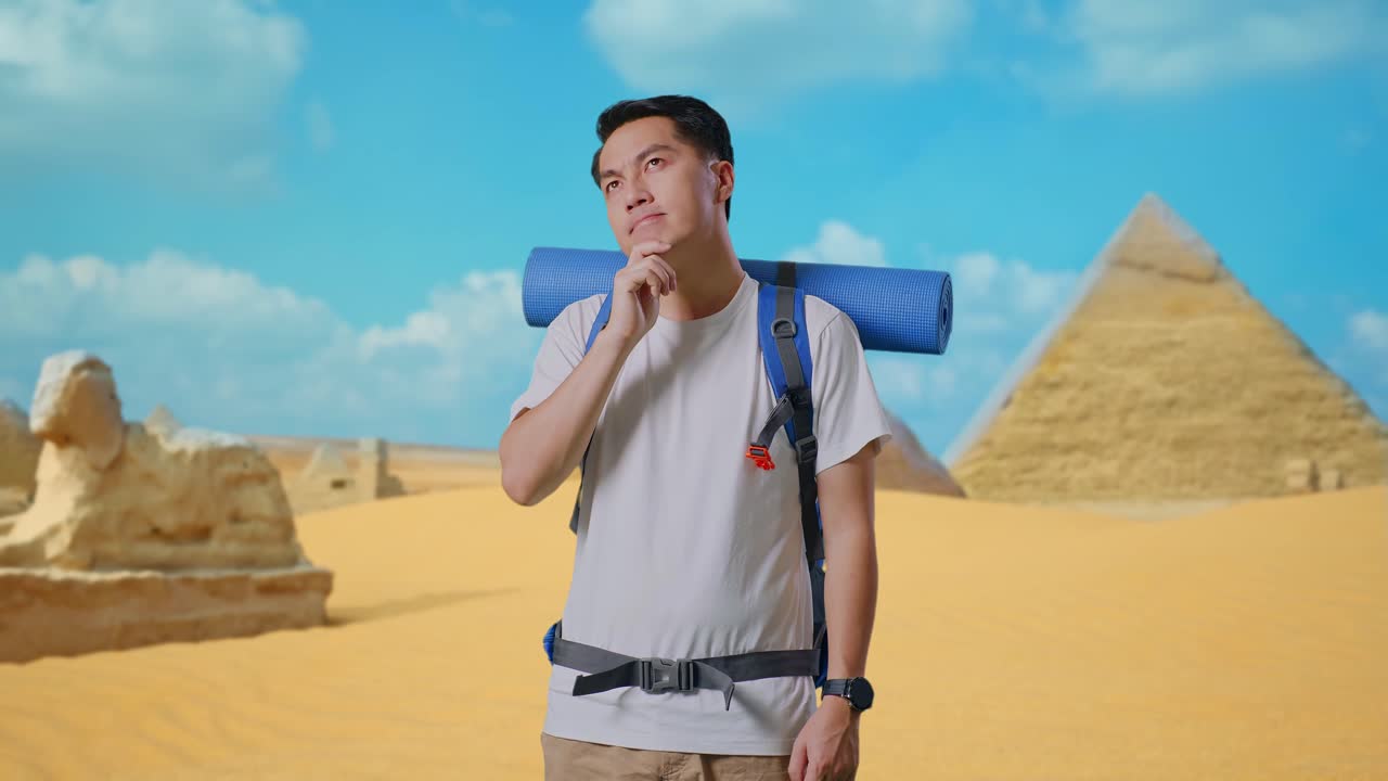Asian Male Hiker With Mountaineering Backpack Thinking About Something And Looking Around While Traveling In Pyramid Of Giza