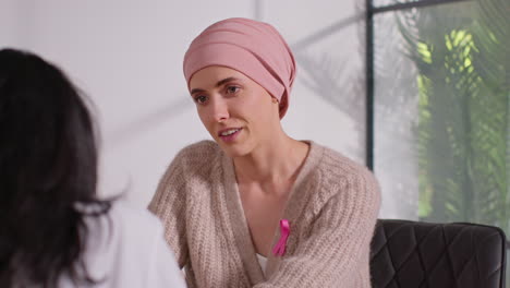 smiling woman patient wearing headscarf undergoing chemotherapy treatment for breast cancer getting good news at meeting with oncologist or doctor in hospital