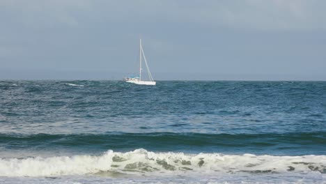 un velero blanco se mueve rápido sobre las olas del mar