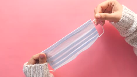 woman's hands holding a face mask