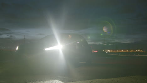 Evening-Scenery-of-Car-in-Front-of-Dramatic-Sky-Switching-on-Lights