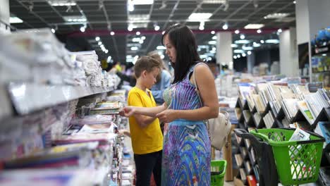 School supplies in supermarket. Kid with parent buying school supplies in a store