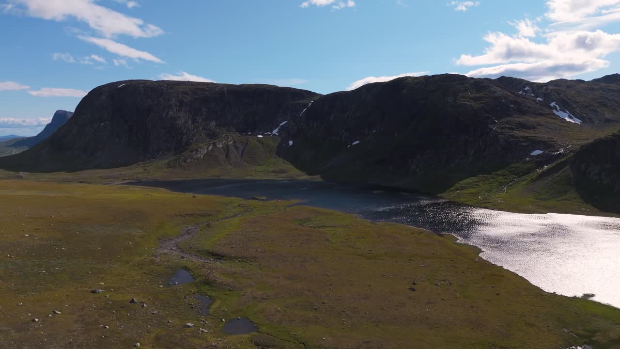 vista aérea de un hermoso paisaje montañoso noruego con cielos despejados y un lago sereno