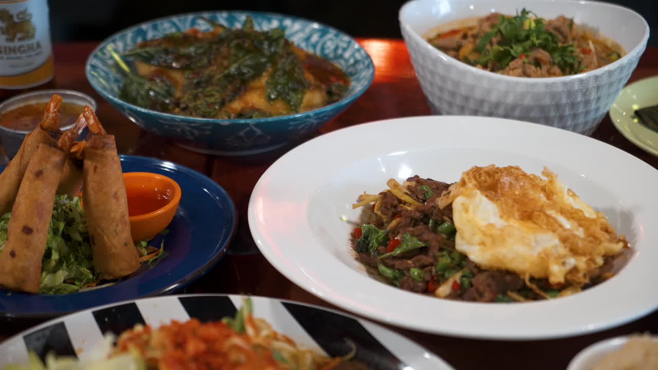 태국 레스토랑의 다양한 메뉴 옵션이 탁상 위에 우아하게 배열되어 슬라이더 4k를 닫습니다.