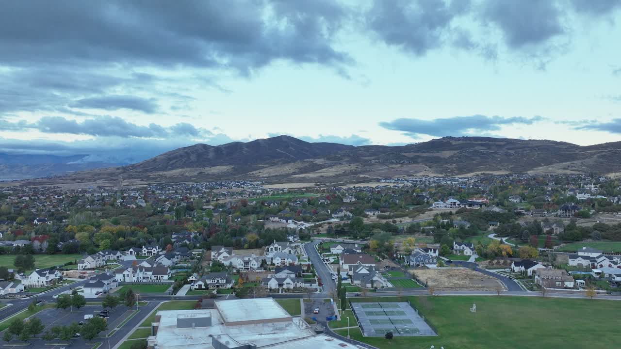 Descending Aerial Shot Of A School And Park At Alpine With Travers Mountain In The Background In Utah