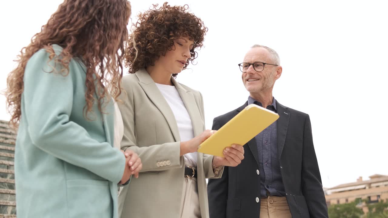 Happy business people with tablet talking on steps