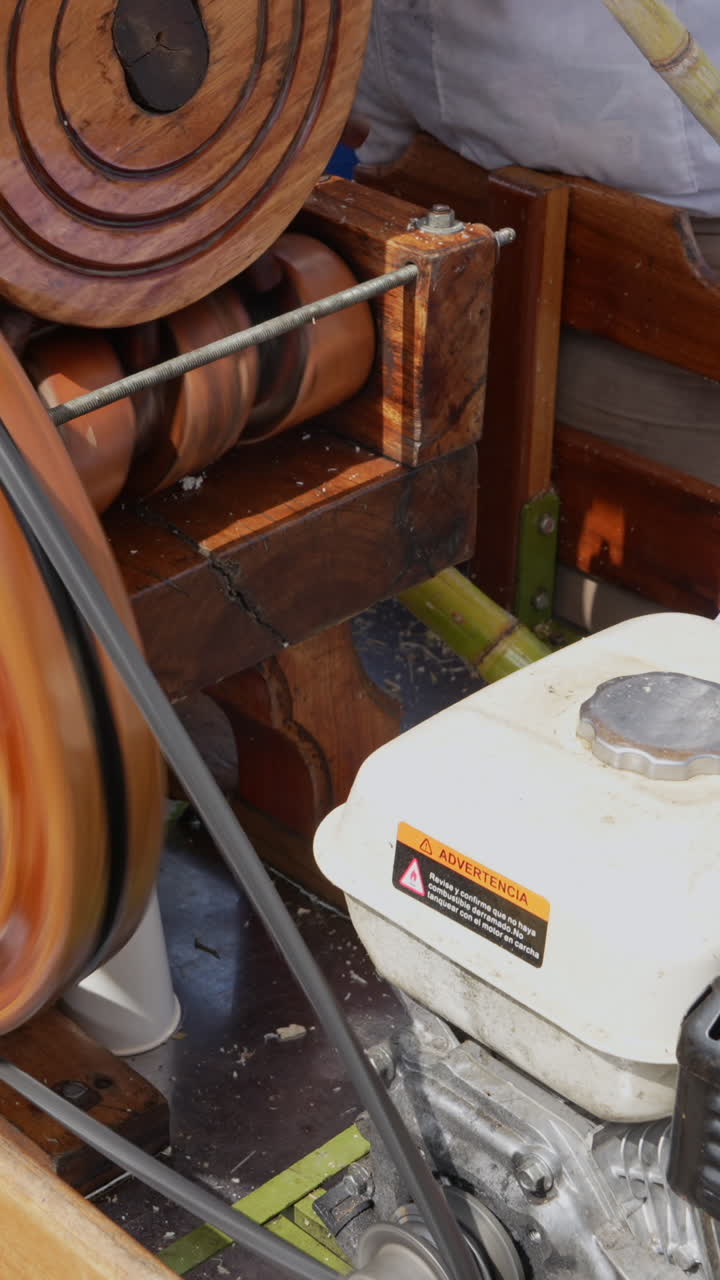 Close-up shot of a trapiche milling sugarcane smoothly in bright light. The vertical video captures intricate machinery details, perfect for mobile, social media, and more