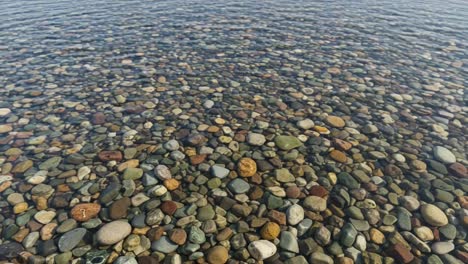 a serene view of colorful pebbles under crystal-clear water: discover the beauty of nature's mosaic at the water's edge