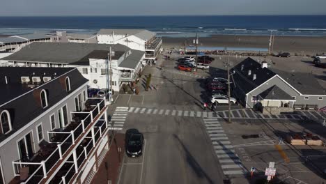 Drone-Vuela-Sobre-Ogunquit-Maine-Usa,-Calle-Pública-Que-Conduce-A-La-Playa-De-Arena-Del-Océano-Con-Turistas-Disfrutando-De-Las-Vacaciones-De-Verano