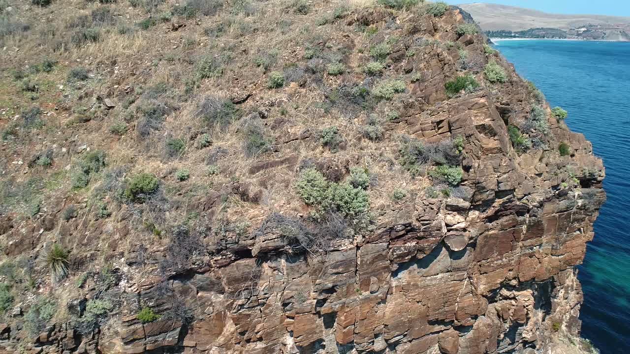 Slow reveal shot of boats anchored in pristine waters amongst tall cliff faces in South Australia