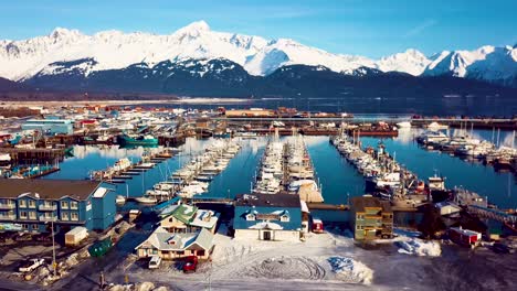 4K-Drone-Video-of-Seward-Boat-Harbor-and-Surrounding-Snow-Covered-Mountains-on-Snowy-Winter-Day-in-Alaska