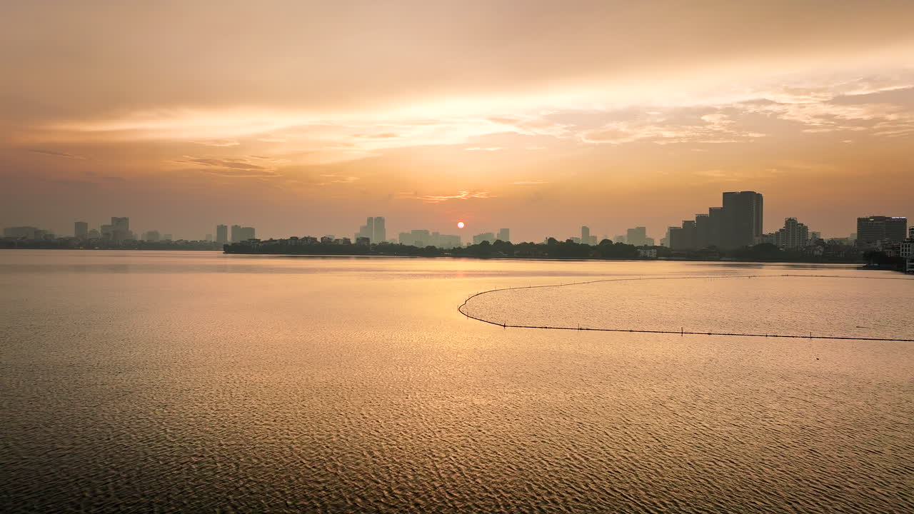 베트남 하노이를 배경으로 해가 지는 서쪽 호수 또는 호타이 위를 날아다니는 드론