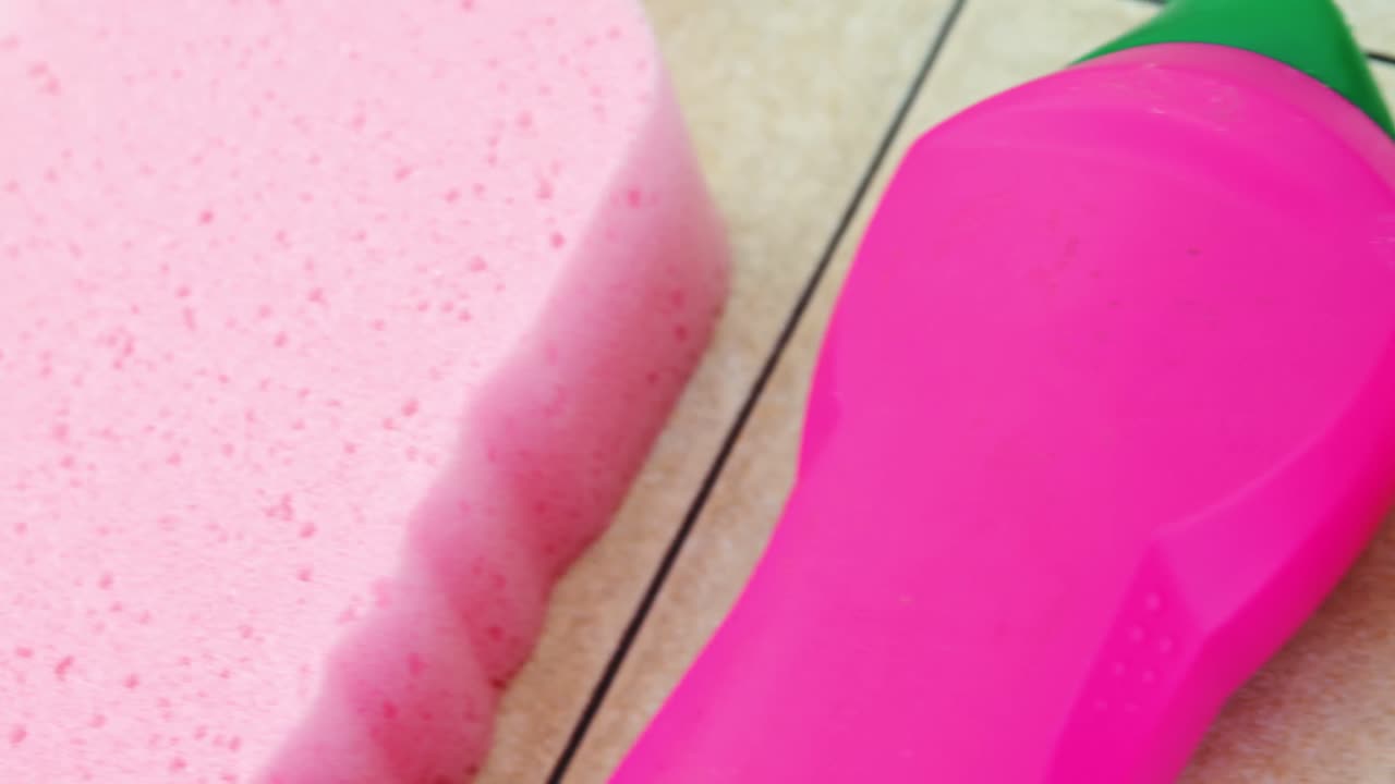 esponja de limpieza con botella de detergente