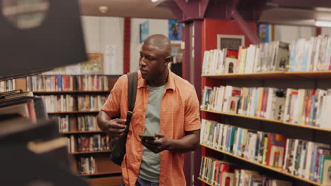 a man using his phone in a library