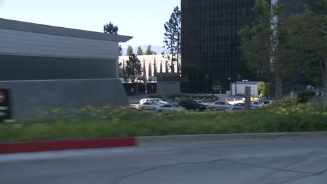 un automóvil viaja a lo largo de una calle en la ciudad del siglo, los ángeles, visto a través de la ventana trasera en un ángulo 5
