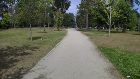padres con niños disfrutando de los juegos del parque público con sus jardines y árboles una soleada mañana de verano