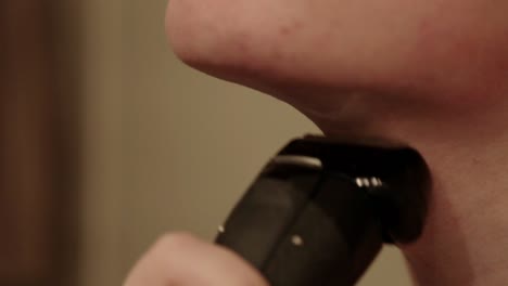 Close-up-shot-of-a-young-person-using-an-electric-shaver-on-their-stubble