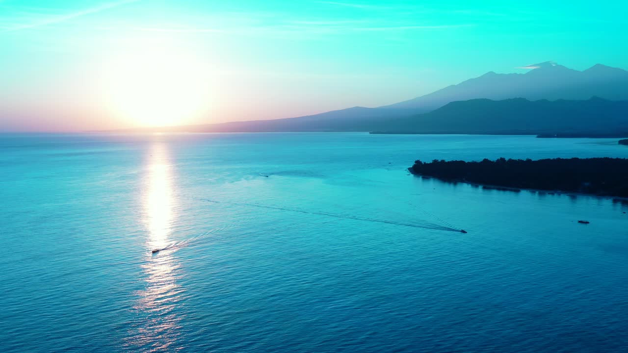 인도네시아 열대만의 잔잔한 수면에 반사되어 빛나는 수평선 아래로 해가 지는 평화로운 바다 풍경