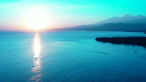 peaceful sea scenery with sun setting down glowing horizon, reflecting on calm water surface of tropical bay in indonesia