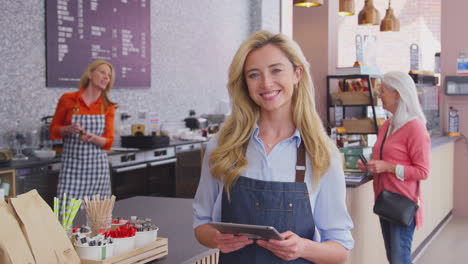 retrato de una mujer propietaria o trabajadora en una cafetería con tableta digital