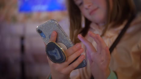 Mädchen-Mit-Telefon-Mit-Bling-Telefon-Und-Poppet-Nachts-Im-Café