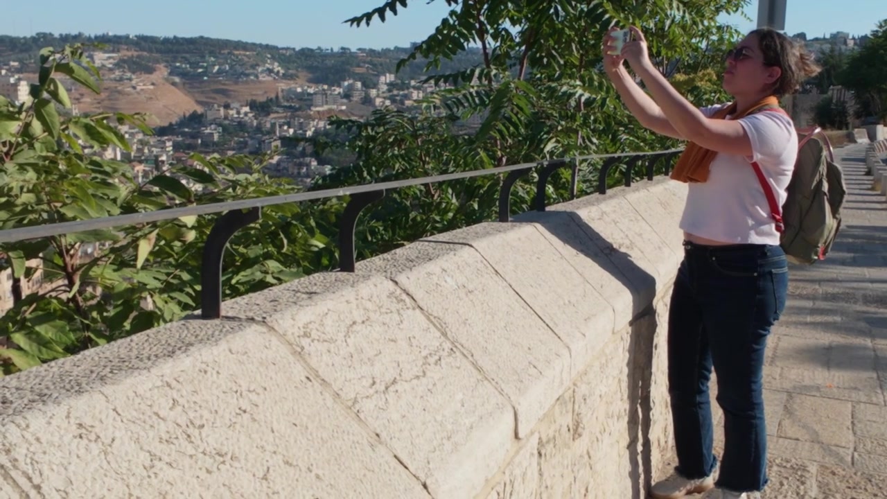 Turista che fotografa il panorama urbano di Gerusalemme con lo smartphone