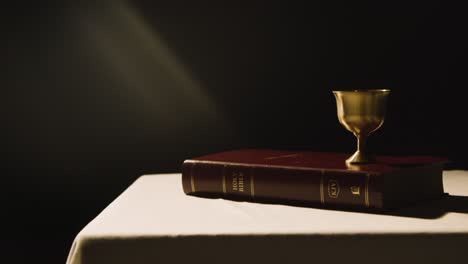 Religious-Concept-Shot-With-Bible-And-Chalice-On-Altar-In-Pool-Of-Light-1