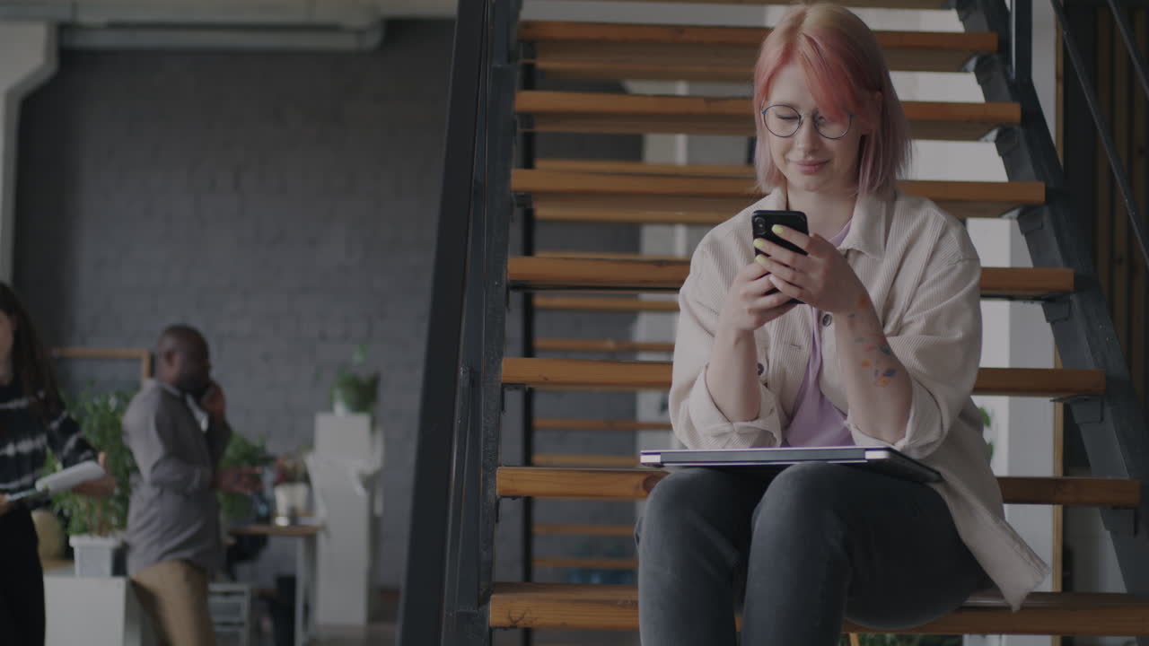 Young Woman Working on Stairs in an Office