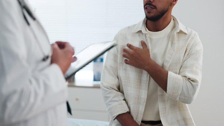 Male Patient Discussing Symptoms with Doctor in Clinic