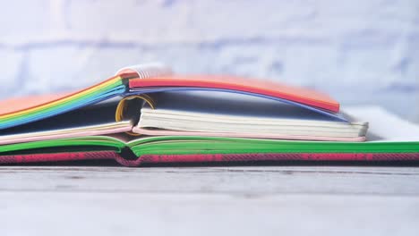 open colorful notebooks on a wooden table