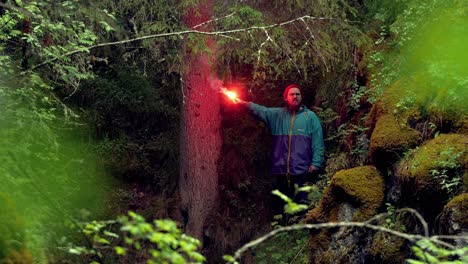 man with red flare in the forest