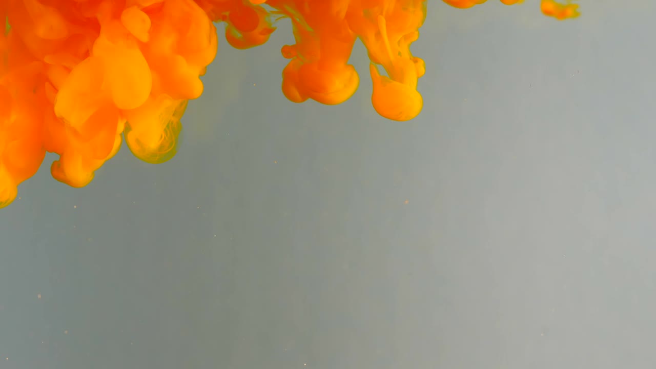 Ink in water. Colour orange glitter paint reacting in water creating abstract cloud formations.Can be used as transitions,added to modern grunge projects,art backgrounds, anything with creative twist