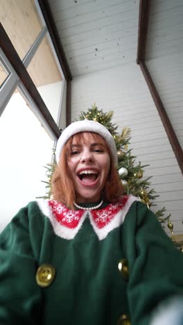 woman wearing a christmas sweater in front of a christmas tree