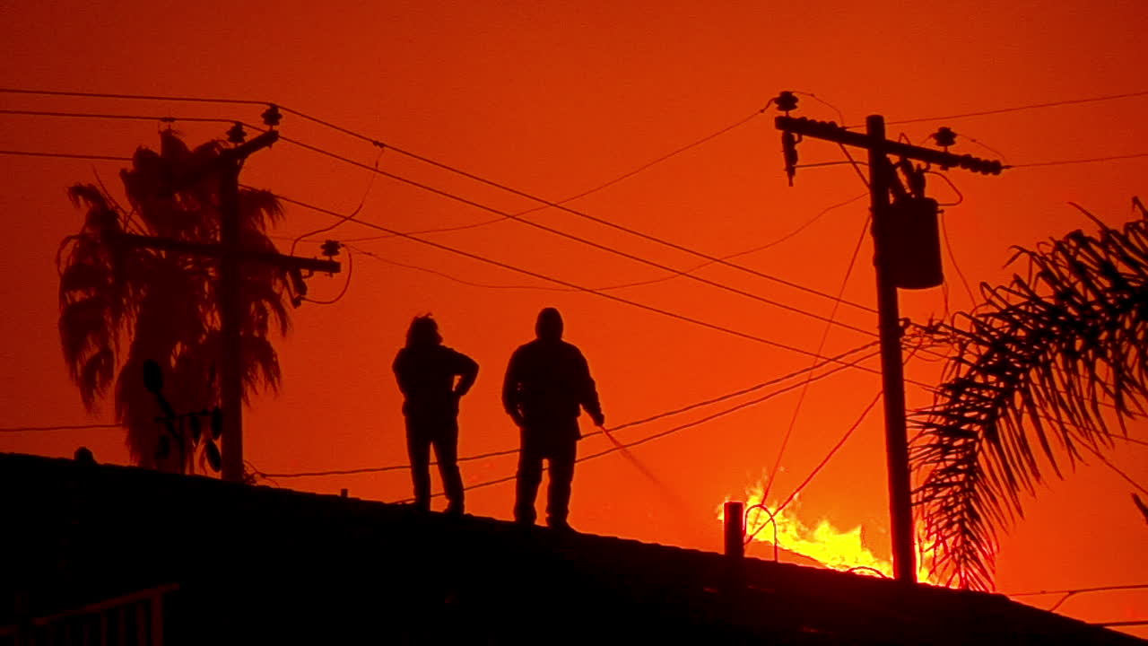 los residentes riegan los techos y patios de sus casas a medida que se acerca el incendio thomas en las colinas de ventura y santa barbara
