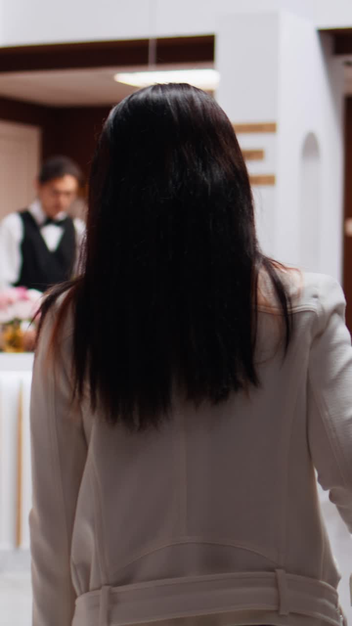 Video verticale: donne asiatiche si avvicinano alla reception per chiedere informazioni sulla loro stanza