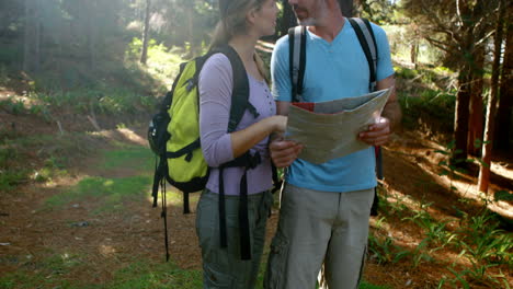 una pareja de excursionistas interactuando mientras miran el mapa