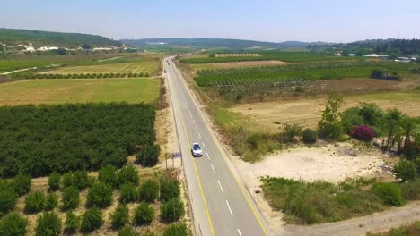 White-car-driving-in-a-colony-near-power-poles