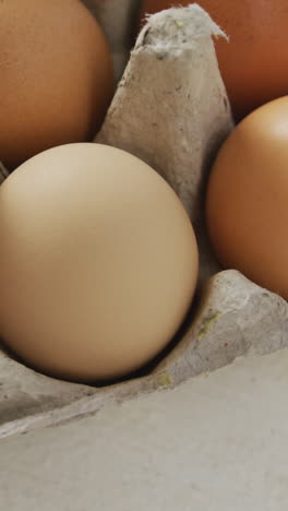 video de primer plano de huevos marrones en cartón de huevos en un fondo rústico