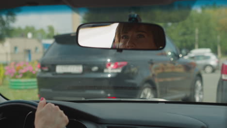 el conductor mira en el espejo del coche para ver la condición de la carretera en la parte trasera