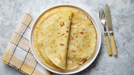 crepes caseros frescos panqueques finos colocados en un plato de cerámica blanca