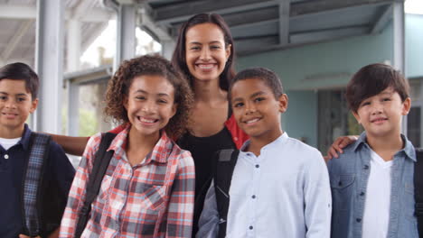 school teacher and her 5th grade students pose in a corridor