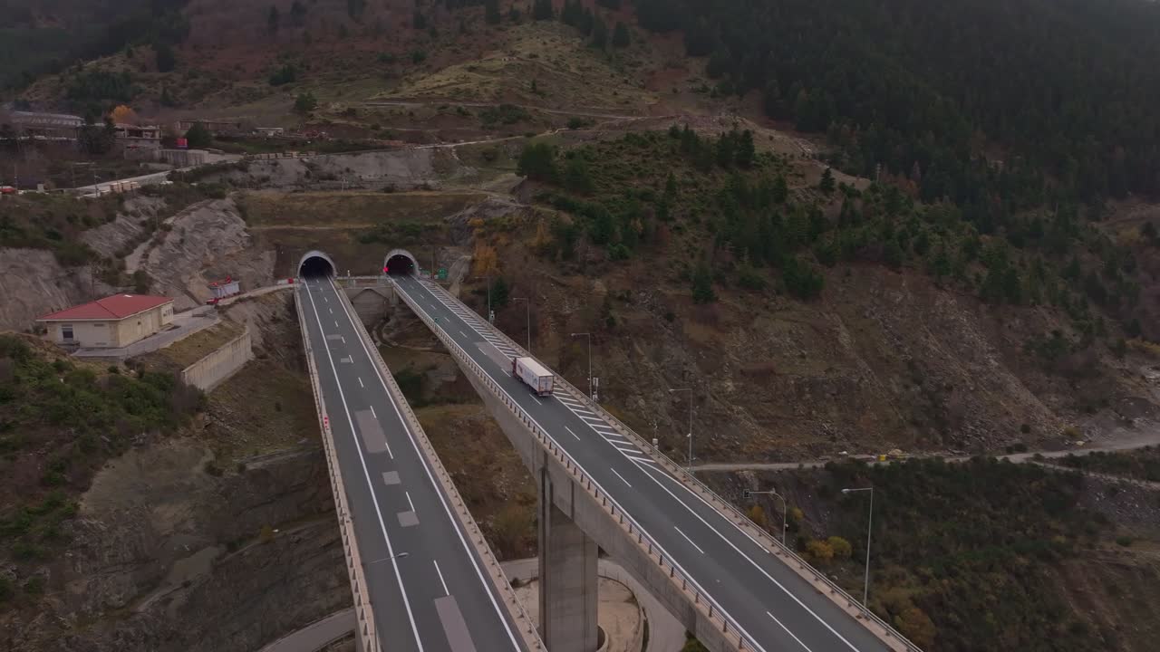Ripresa aerea di un'autostrada panoramica che si snoda in una galleria di montagna.